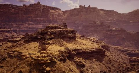 Rock formations rise dramatically under a hazy sky in a desert landscape 스톡 일러스트