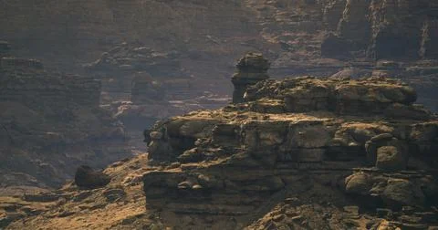 Rock formations rise majestically under soft light in a rugged landscape Stock Illustration