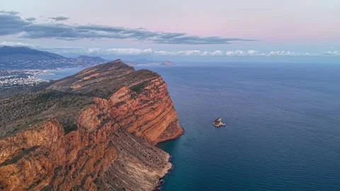 Rock formations with tranquil waters. Serene sea surrounds isolated hill beneath Stock Footage 342360949