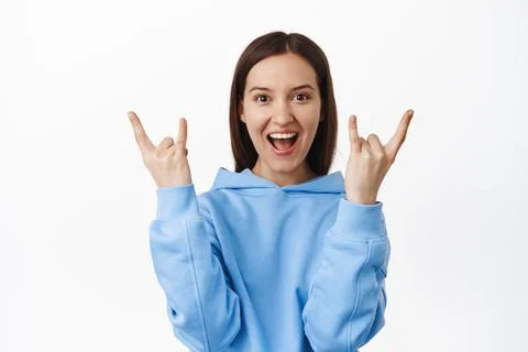 Rock on, lets get party started. Excited 20s girl celebrating, showing heavy Fotos Stock
