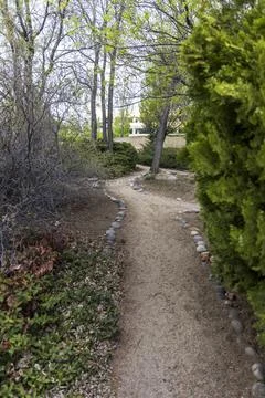 Rock lined path through trees in a park Stock Photos