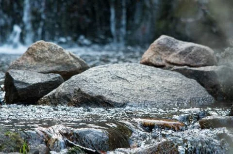 Rock in the middle of a flowing stream Stock Photos