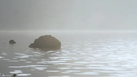 Rock on Misty Lake Stock Footage 87157254
