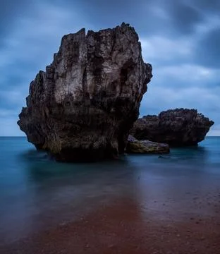 Rock in the ocean in the evening Stock Photos