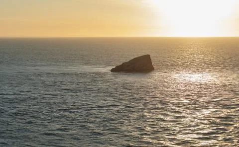 Rock in ocean at sunset Stock Photos