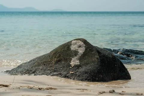 Rock with Painted Question Mark on Tranquil Beach Foto stock