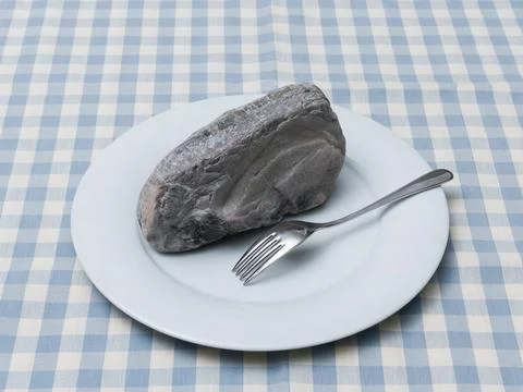 Rock on Plate Metaphor for Digestion Problems and Heavy Meal Stock-Fotos