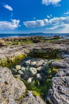 Rock pool at Osmington Reflecting Sunset Colours Stock Photos