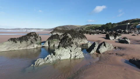 Rock pools along Woolacombe beach at sunrise Stock Footage 142434034