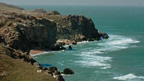 The rock on the seashore is washed by the tide, with dried steppe grass on top Stock Footage 220632782