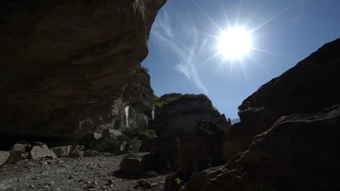 Rock Silhouettes Under Sun Rays with Twin Waterfalls in the Distance 動画素材 318833394