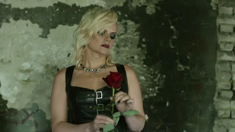 Rock singer posing with red rose in abandoned building Stock Footage 301329212