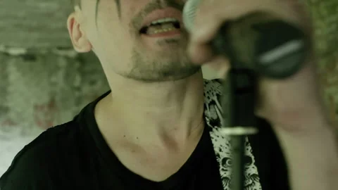Rock singer singing with passion into microphone with bandmate playing drums Video stock 301273365