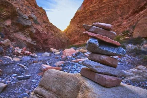 Rock Stack Cairn in Dramatic Red Canyon at Sunset with Rugged Natural Landsca Foto stock