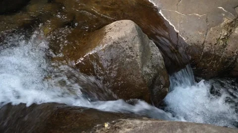 Rock in stream of flowing water Stockbeeldmateriaal 211820561
