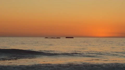 A rock at sunset with waves in the foreground Video stock 144574970