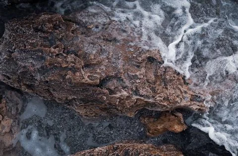 A rock surrounded by the sea. Stock Photos
