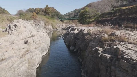 Rock Valley River Flight Toward Steel Bridge | 4K Cinematic Drone Footage Stock Footage 325411516