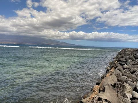 A Rock Wall with a Surf Break in the Background Foto stock