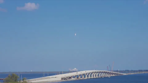 Rocket Launch Over Bridge with Cars Crossing Blue Water on Sunny Day Stock Footage 337905848