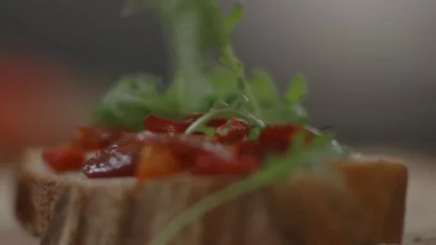 Rocket leaves being put onto tomatoes and pepperoni in sandwich Stock Footage 194478483