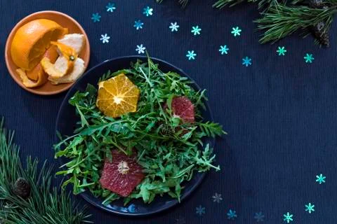 Rocket salad with oranges and grapefruit on a blue plate Stock Photos