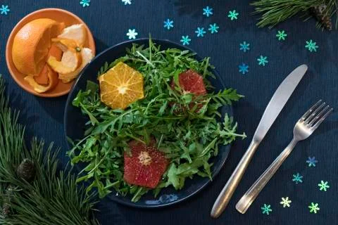 Rocket salad with oranges and grapefruit on a blue plate Stock Photos