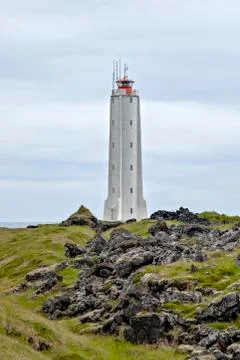 Rocket-shaped lighthouse surrounded by volcanic rocks Stock Photos
