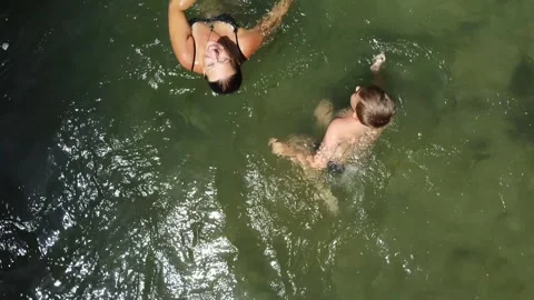 Rocket Shot of Mother and Son Swimming in Crystal Clear Mountain River Video stock 330506331