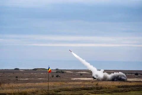 Rocket soaring in the sky, with a billowing cloud of smoke trailing behind it Stock Photos