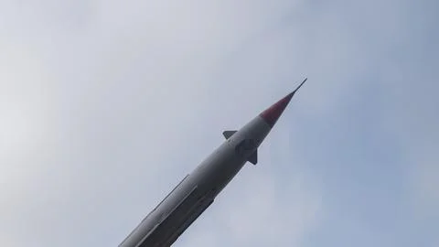 Rocket tip perspective, detailed view of missile tip with overcast clouds and Foto stock