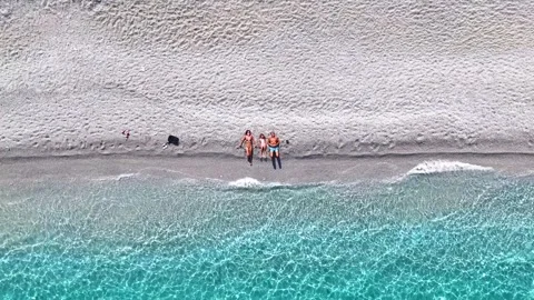 A rocket view of a family lying on beach Stock Footage 294977413