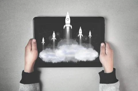 Rockets flying over clouds on tablet screen. Business Startup Stock Photos