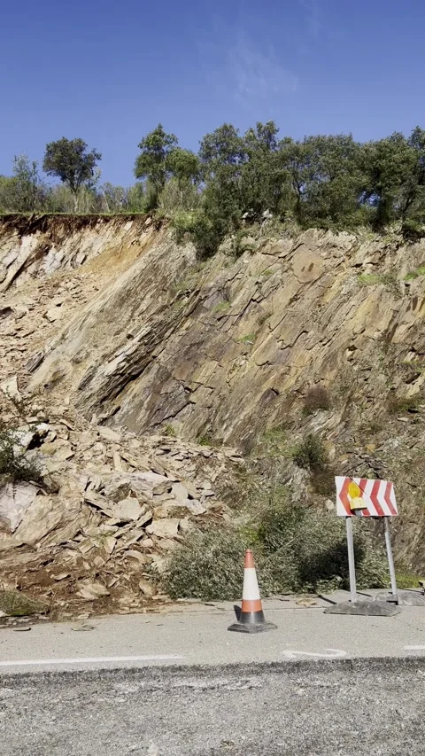 Rockfall blocking mountain road with warning barriers Stock Footage 328973227