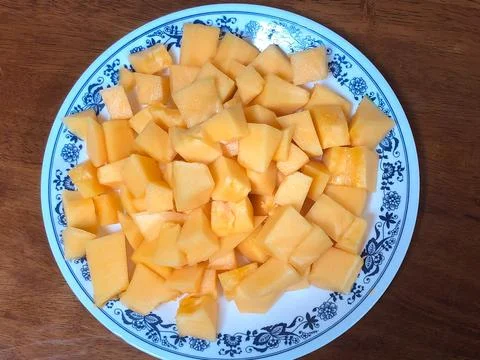 Rockmelon cut into small cubes served in a plate Stock Photos