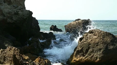Rocks about which break sea foamy waves. Stock Footage 104620786