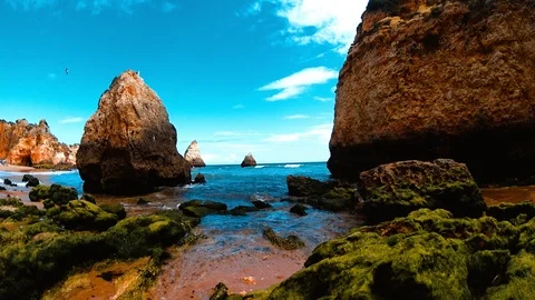 Rocks with an algae and moss on beach splashing by ocean waves, Alvor, Portugal Stock Footage 92438669