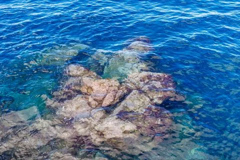 Rocks and cliffs visible underwater from the surface of the Atlantic Ocean... Stock Photos