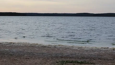 Rocks and pebbles along beach lake shore with waves washing on shore Stock Footage 168840331