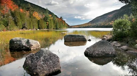 Rocks and relfections in still fall lake in acadia national park Stock Footage 55016591