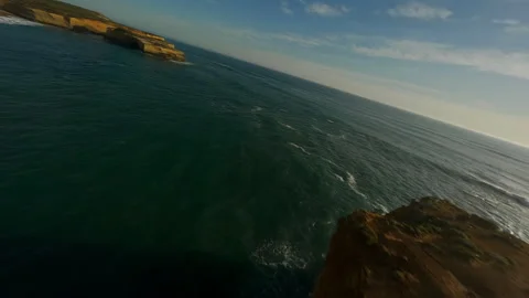 Rocks and a sandy cliff by the ocean in Australia Stock Footage 240370317