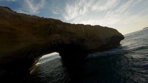 Rocks and a sandy cliff by the ocean in Australia Stock Footage 240370386