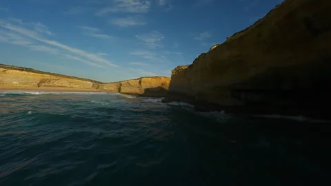 Rocks and a sandy cliff by the ocean in Australia Stock Footage 240370472