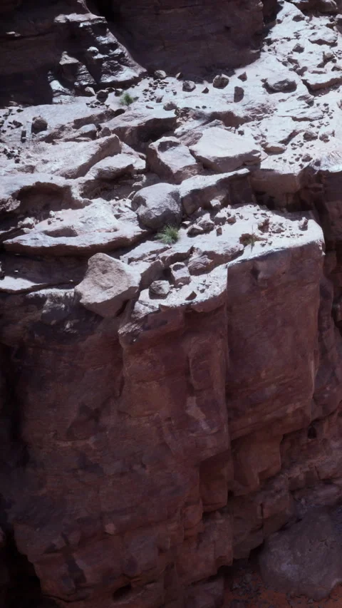 Rocks and stones on a dry cliff face in a desert landscape during daylight Stock Footage 337975963