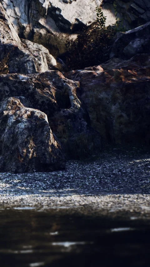Rocks and water reflect sunlight in nature near a riverbank at midday 動画素材 340633571