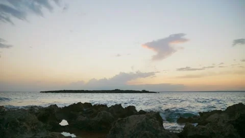 Rocks bathed by the ocean with sky, sundown Stock Footage 131350138