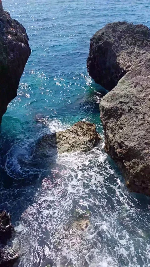 The rocks on the beach are hit by ocean waves Stock Footage 297035682