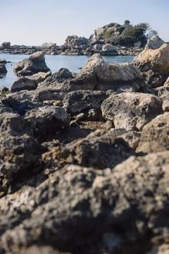 Rocks on the beach with cloudless sky Stock Photos