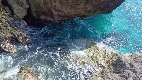 Rocks on the beach hit by ocean waves. High angle view Stock Footage 297136578