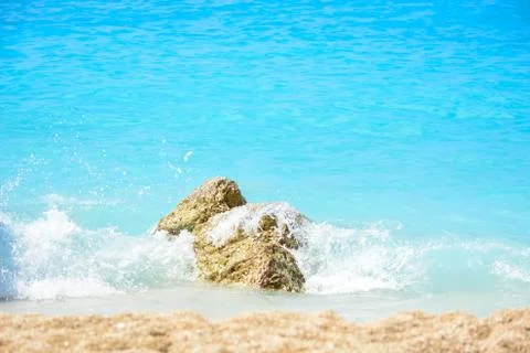Rocks on the beach hit by waves Stockfoto's